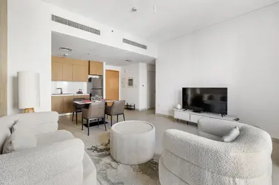 a living room with two couches and a dining room at Bright 1BR with Balcony Creek Beach Access in Dubai