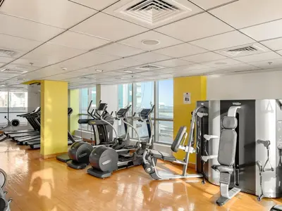 a gym with several treadmills and cardio machines at FIRST CLASS 1BR Scenic Marina Views in Dubai