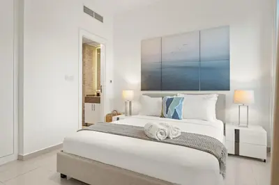 a white bedroom with a large bed with towels on it at FIRST CLASS 1BR Scenic Marina Views in Dubai