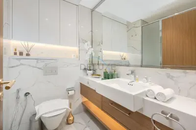 a white bathroom with a toilet and a sink at Perfectly Positioned Near the Park and Meydan Racecourse, Just a 20-Minute Drive to Global Village, Azizi Riviera 65, Al Merkadh by Deluxe Holiday Homes in Dubai