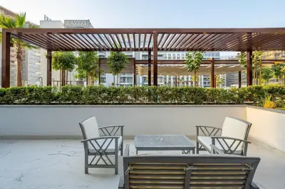 a patio with chairs and tables on a building at Perfectly Positioned Near the Park and Meydan Racecourse, Just a 20-Minute Drive to Global Village, Azizi Riviera 65, Al Merkadh by Deluxe Holiday Homes in Dubai