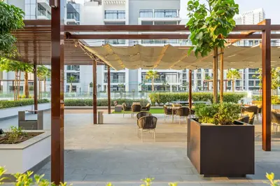a patio with tables and chairs in a building at Perfectly Positioned Near the Park and Meydan Racecourse, Just a 20-Minute Drive to Global Village, Azizi Riviera 65, Al Merkadh by Deluxe Holiday Homes in Dubai