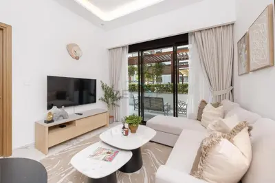 a white living room with a white couch and a tv at Perfectly Positioned Near the Park and Meydan Racecourse, Just a 20-Minute Drive to Global Village, Azizi Riviera 65, Al Merkadh by Deluxe Holiday Homes in Dubai