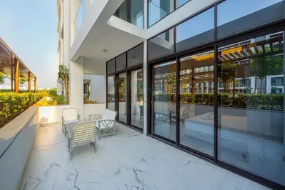 a large building with glass windows and a patio at Perfectly Positioned Near the Park and Meydan Racecourse, Just a 20-Minute Drive to Global Village, Azizi Riviera 65, Al Merkadh by Deluxe Holiday Homes in Dubai