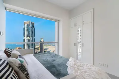 a bedroom with a large window with a view of the city at The Smart Concierge - Marina tower in Dubai