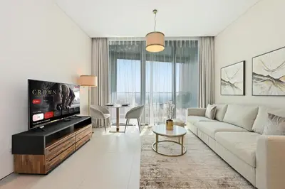 a living room with a couch and a tv at New & Beautiful 1BD Apartment in Address JBR in Dubai