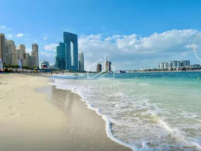 a beach with the ocean and buildings in the background at New & Beautiful 1BD Apartment in Address JBR in Dubai