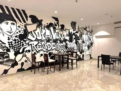 a dining room with a wall with a mural at Joya Verde Residence - Studio with Balcony in Dubai