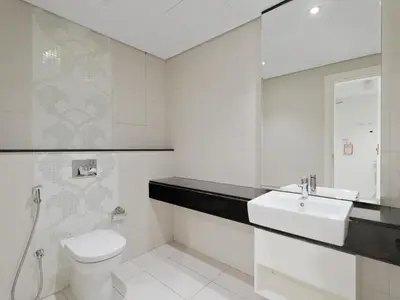 a white bathroom with a sink and a toilet at Water Edge Damac Maison Canal View 1BR Perfect Grand Getaway in Dubai