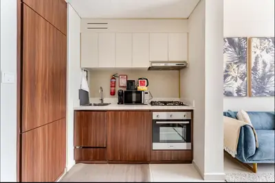 a small kitchen with a stove and a microwave at Elegant 1BR Apartment at DAMAC Vera in Business Bay in Dubai