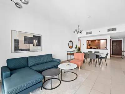 a living room with a blue couch and a table at Luxury 2-BDR in Downtown 8 BLVD Walk in Dubai