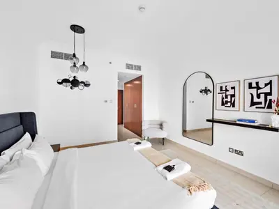 a white bedroom with a bed and a mirror at Luxury 2-BDR in Downtown 8 BLVD Walk in Dubai