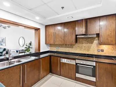 a kitchen with wooden cabinets and a sink at Luxury 2-BDR in Downtown 8 BLVD Walk in Dubai