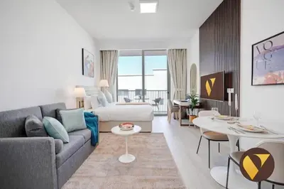 a living room with a couch and a table at Vogue JVC Luma22 near Circle Mall, Studio Apartment with Balcony and Vibrant Community View, Access to all Amenities in Dubai