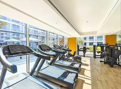 a row of treadmills in a gym at Vogue JVC Luma22 near Circle Mall, Studio Apartment with Balcony and Vibrant Community View, Access to all Amenities in Dubai