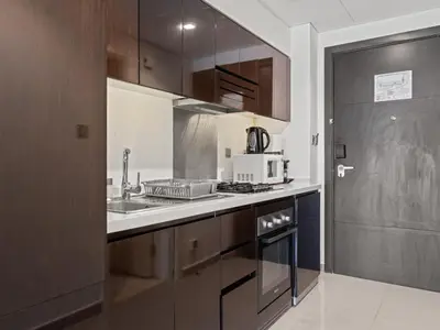 a kitchen with a sink and a microwave at Sunlit Studio Haven Luxury Living in Majestine in Dubai