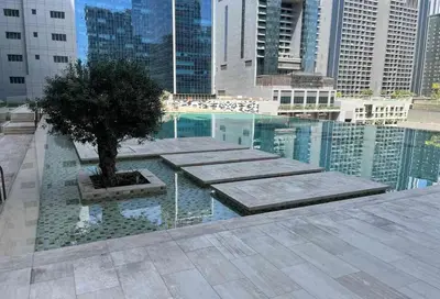 a pool with a tree in the middle of a city at Sunlit Studio Haven Luxury Living in Majestine in Dubai