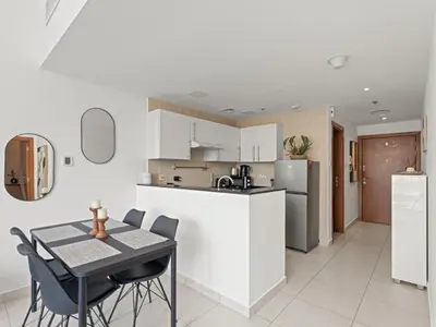 a kitchen and dining room with a table and chairs at Prime Luxe 1BR w SofaBed -Sleeps 4 - In Marina View in Dubai