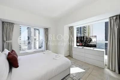 a bedroom with a large bed and a large window at Bloomfields Iconic 2BR Elite Residence Marina in Dubai