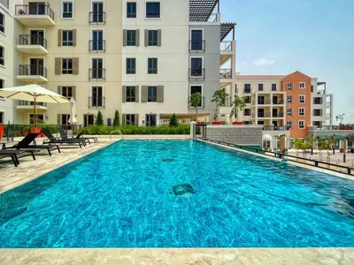 a large swimming pool in front of a building at Port De La Mer by Hosteeva in Dubai
