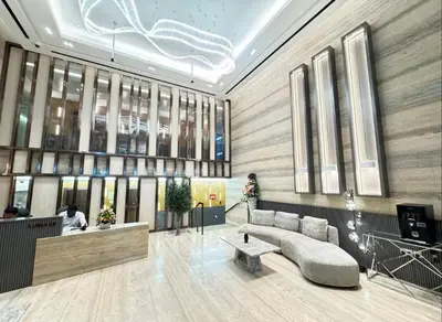 a lobby with a couch and a table in a building at Vogue JVC Luma22 near Circle Mall, Studio Apartment with Balcony and Vibrant Community View, Access to all Amenities in Dubai