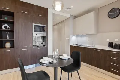 a dining room with a table and chairs in a kitchen at Upscale Studio in Park View JVC in Dubai