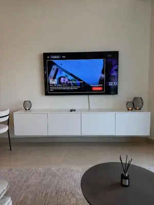 a flat screen tv sitting on top of a white cabinet at Magical Views Downtown Lux 2 BR Urban Resort in Dubai