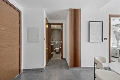 a hallway leading to a bathroom with a toilet at Luxury 1BR Apartment Near Burj Khalifa Skyline Pool View in Dubai