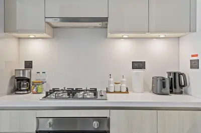 a kitchen with a stove and a counter top at Luxury 1BR Apartment Near Burj Khalifa Skyline Pool View in Dubai