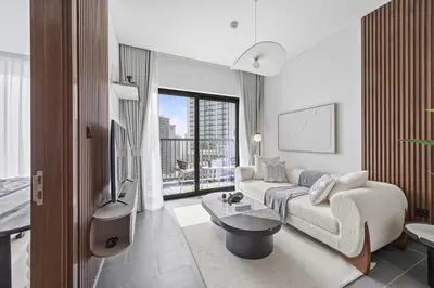 a living room with a couch and a table and a tv at Luxury 1BR Apartment Near Burj Khalifa Skyline Pool View in Dubai