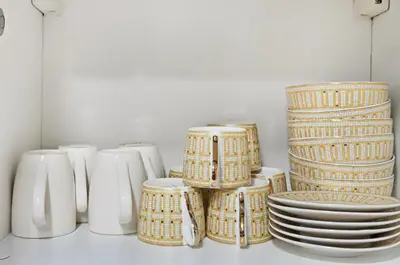 a bunch of plates and bowls and plates on a shelf at Ultra Modern Downtown Residence Steps Away from Burj Khalifa and Dubai Mall in Dubai