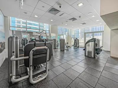 a gym with rows of exercise equipment in a building at Ultra Modern Downtown Residence Steps Away from Burj Khalifa and Dubai Mall in Dubai