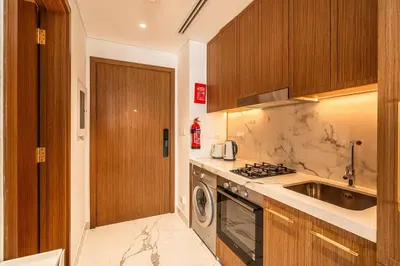 a kitchen with a sink and a washing machine at Modern Studio Apartment with Outdoor views I Azizi 67 in Dubai