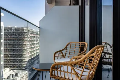 a balcony with two chairs and a table and a window at Modern Studio Apartment with Outdoor views I Azizi 67 in Dubai