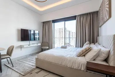 a bedroom with a bed and a large window at Modern Studio Apartment with Outdoor views I Azizi 67 in Dubai