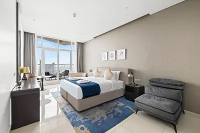 a bedroom with a king sized bed and a chair at Beautiful unit with canal view ! DAMAC PRIVE in Dubai