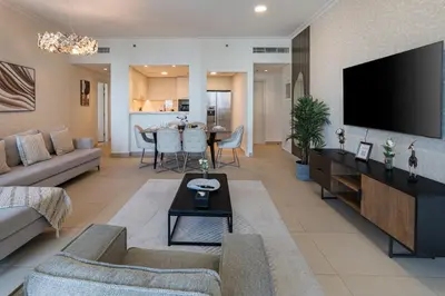 a living room with a couch and a tv at Connection to Dubai Mall, 2 King Beds, with Pool, Gym, Tennis Court in Dubai