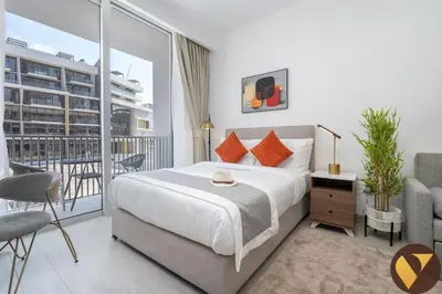 a bedroom with a bed and a balcony at Vogue JVC Luma22 near Circle Mall, Studio Apartment with Balcony and Vibrant Community View, Access to all amenities in Dubai