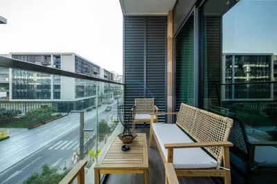 a balcony with two chairs and a table on a building at Prime location near the park, just minutes from the metro, with easy access to all of Downtown Dubai attractions, Viridian, Al Wasl by Deluxe Holiday Homes in Dubai