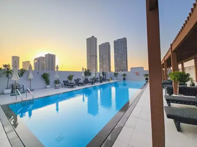 a large swimming pool on top of a building at Vogue JVC Luma22 near Circle Mall, Studio Apartment with Balcony and Vibrant Community View, Access to all Amenities in Dubai