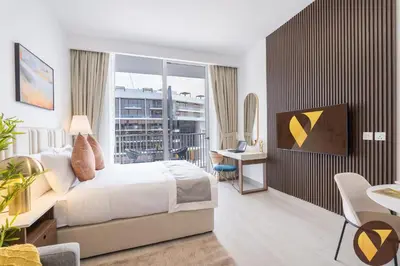 a bedroom with a large bed and a balcony at Vogue JVC Luma22 near Circle Mall, Studio Apartment with Balcony and Vibrant Community View, Access to all Amenities in Dubai