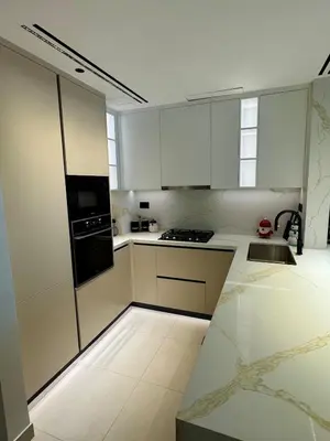 a kitchen with white cabinets and a stove top oven at Brand New Luxury Home in a prime location in Dubai