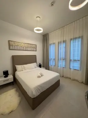 a bedroom with a large bed and two windows at Brand New Luxury Home in a prime location in Dubai