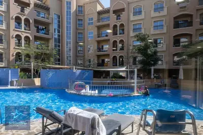 a large swimming pool in front of a building at Peaceful 1BR JVC Near Circle Mall Pool Gym in Dubai