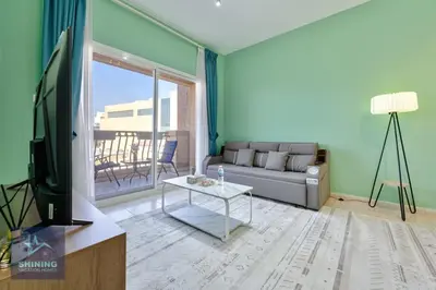 a living room with a couch and a tv at Peaceful 1BR JVC Near Circle Mall Pool Gym in Dubai