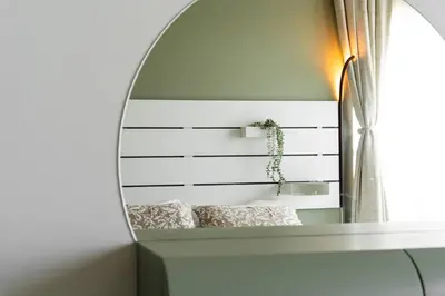 a mirror on a wall with a bed in a room at Meydan Boutique Loft Near Downtown in Dubai