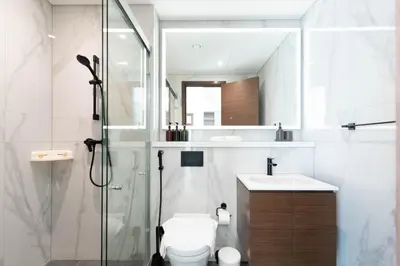 a bathroom with a shower and a toilet and a sink at Luxury 3BR Skyline Apartment - Sobha The Crest Dubai in Dubai