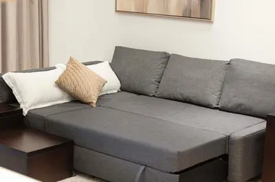 a gray couch with two pillows on it in a living room at Enjoy 8-Day NYE Spectacles with Burj Khalifa View in Dubai