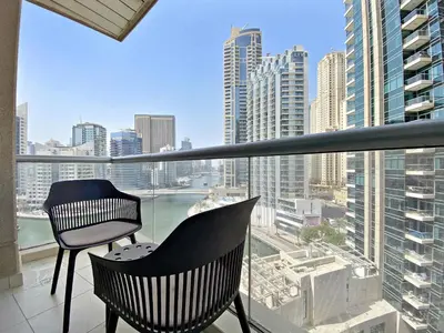 a balcony with two chairs and a view of a city at VayK - Exquisite 2BR with Panoramic Marina View in Dubai