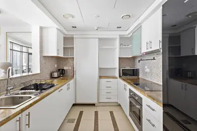a kitchen with white cabinets and a sink at VayK - Exquisite 2BR with Panoramic Marina View in Dubai